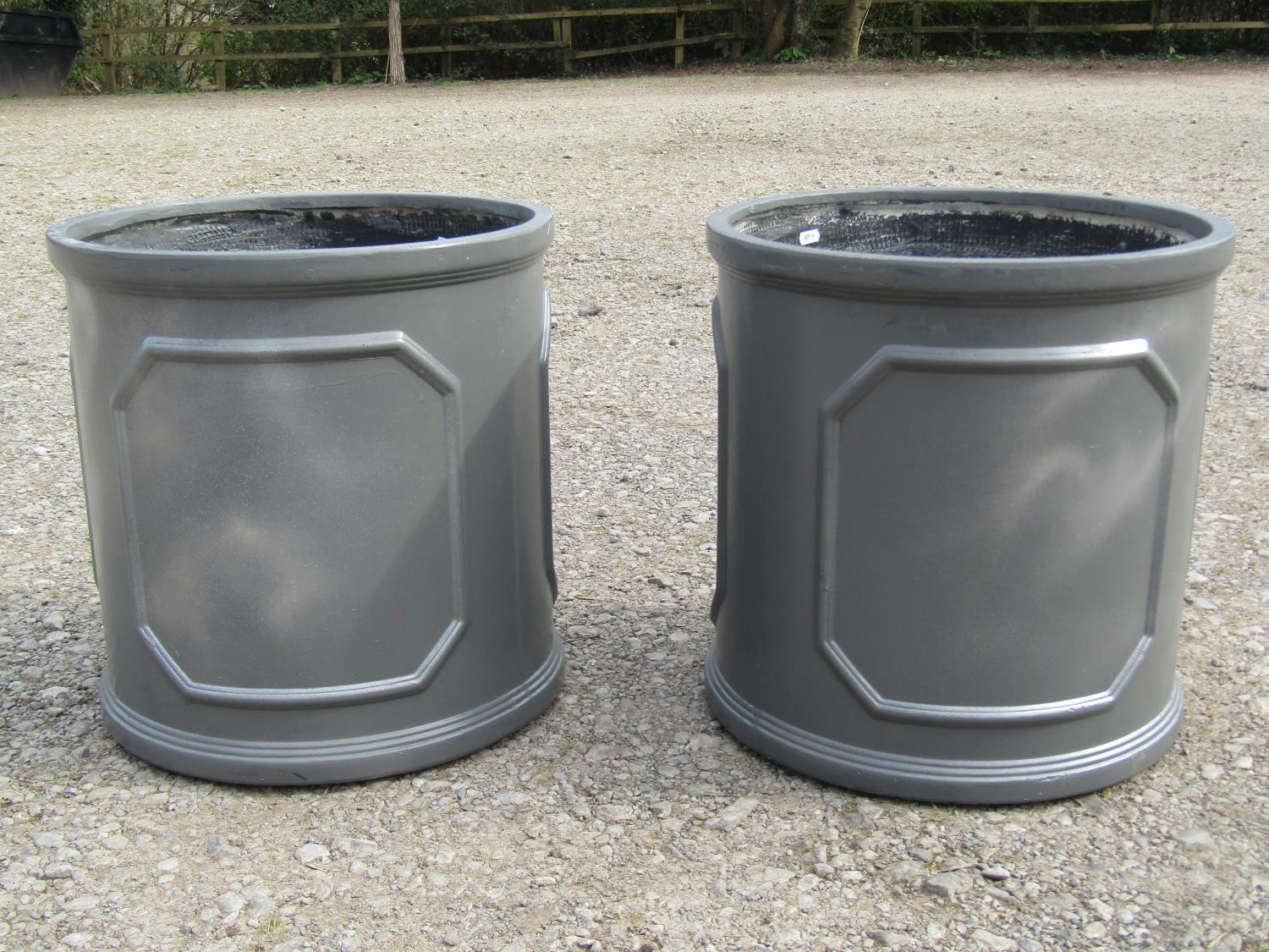 A pair of cylindrical fibre glass to simulate lead garden planters with repeating panels 45 cm