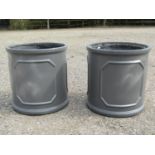 A pair of cylindrical fibre glass to simulate lead garden planters with repeating panels 45 cm