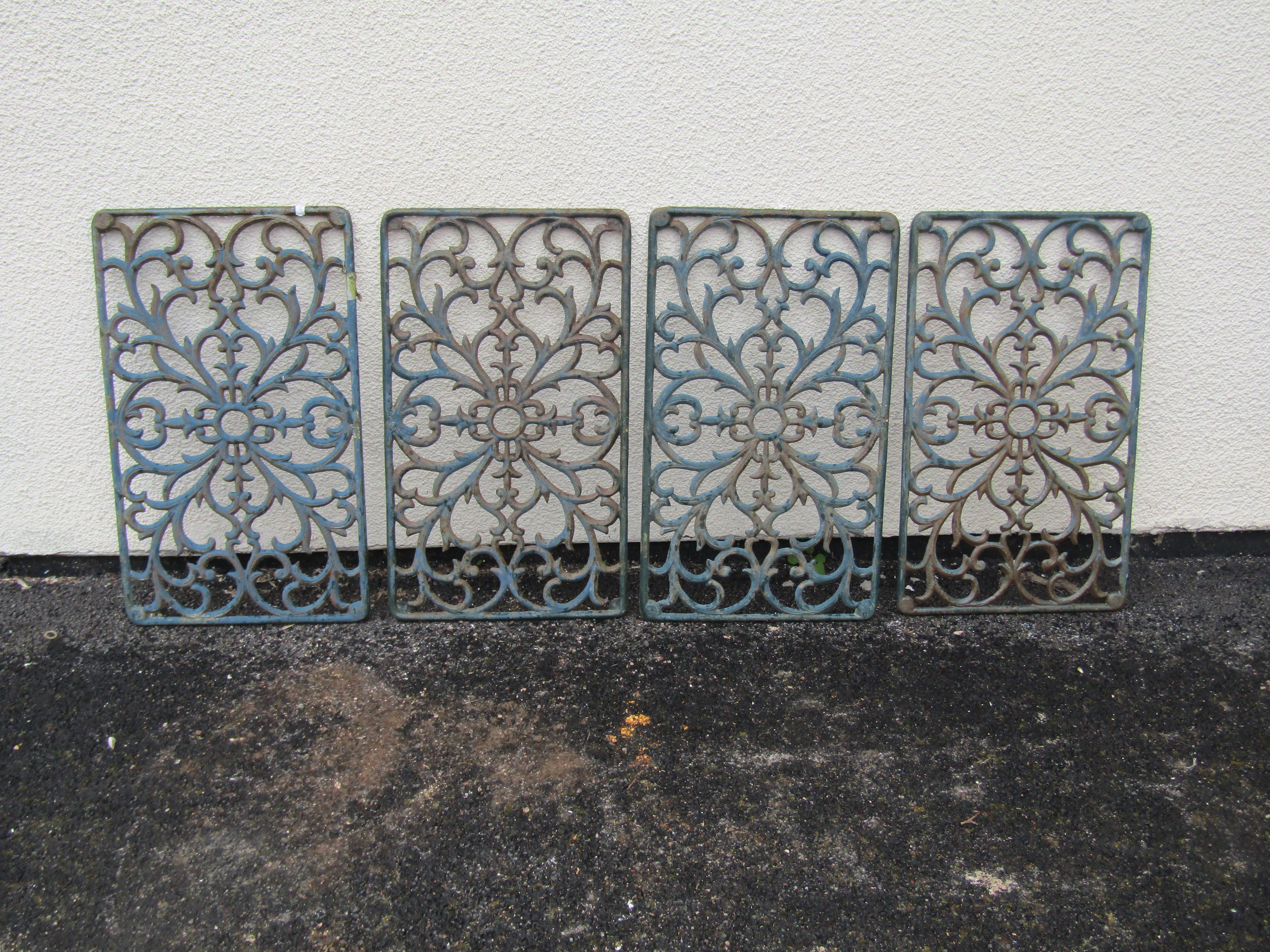 Four rectangular cast iron panels with pierced scrolling foliate detail, 59cm x 35cm