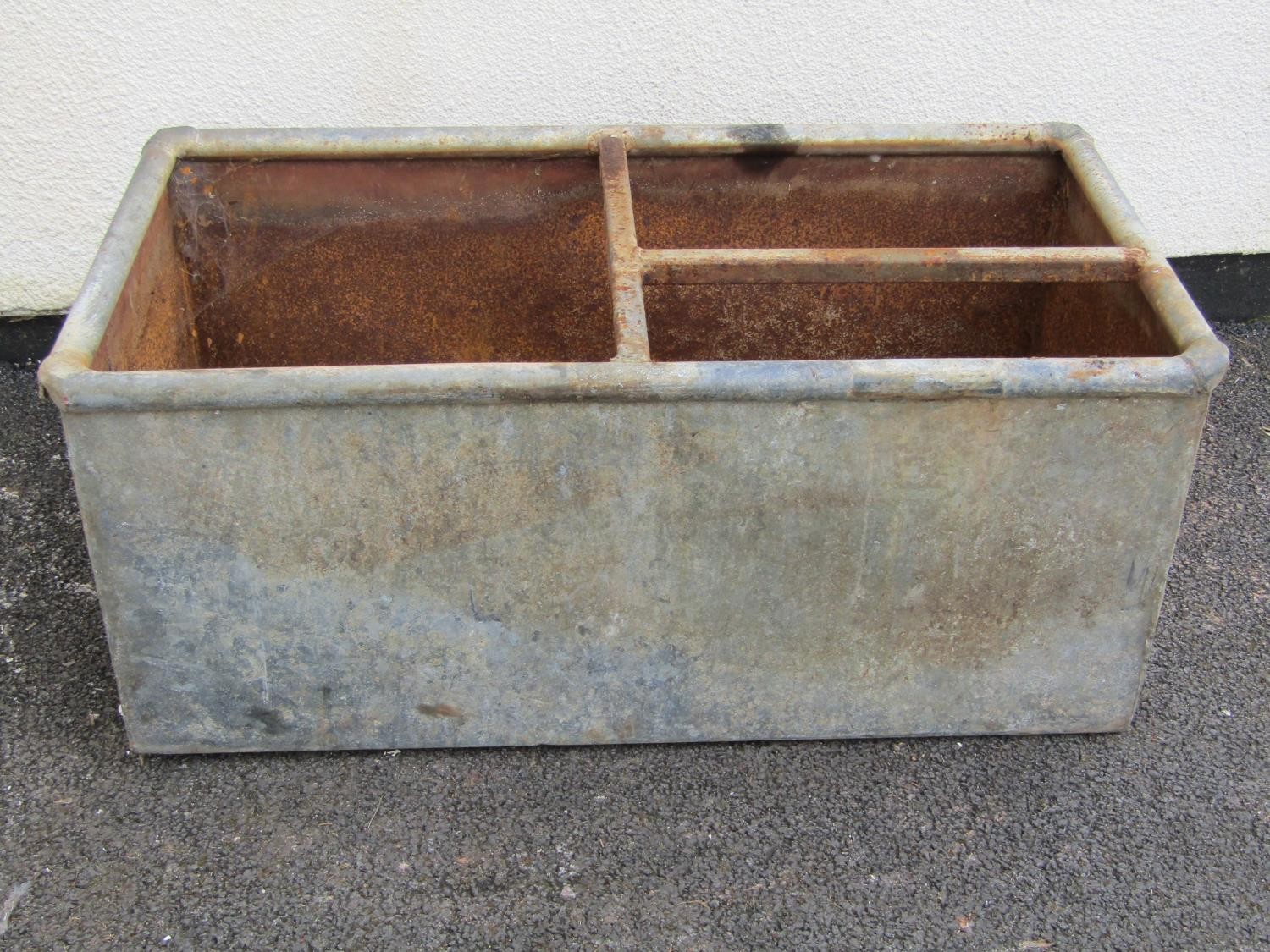 A rectangular galvanised steel water trough with rounded rim with simple bar division 40 cm high x