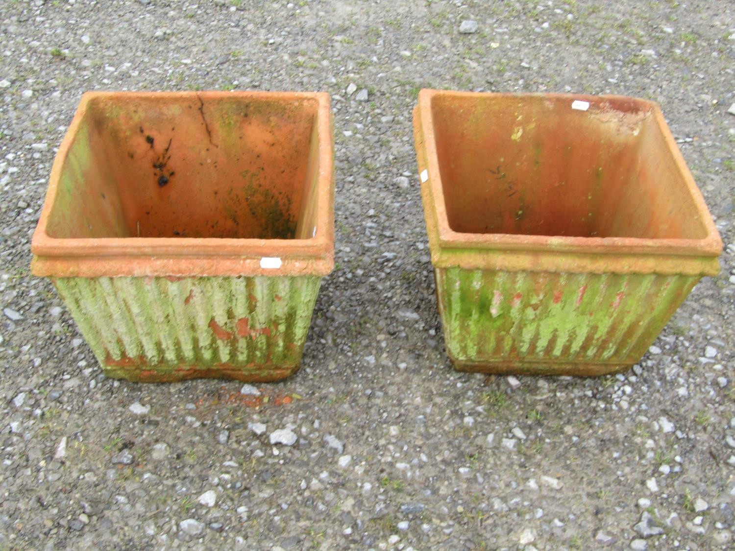 A pair of weathered terracotta square tapered and reeded planters, 30 cm high x 38 cm square