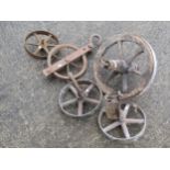 Three small vintage cast iron wheels approx 30 cm diameter together with an old wooden barrow
