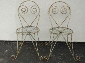 A pair of weathered painted garden / patio chairs, with scrolling framework and wire work seats (2)