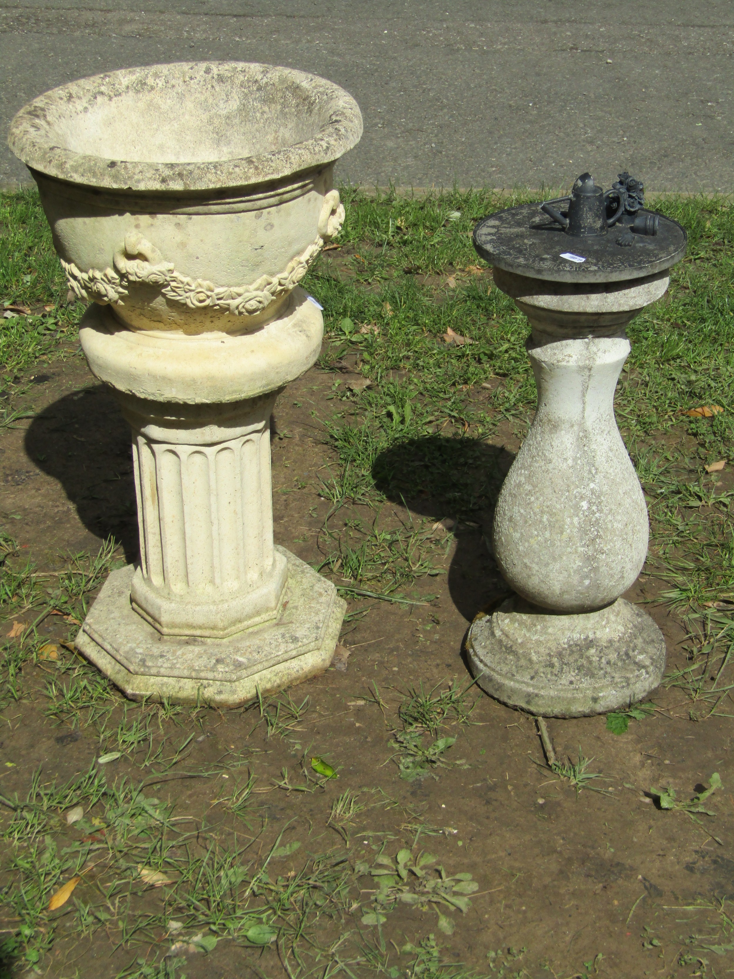 A small weathered cast composition stone garden urn, the circular bowl with flared rim and repeating