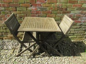 A contemporary wooden three piece folding terrace set with square slatted top table, and a pair of