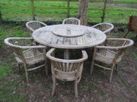 A good quality large weathered (silvered teak) circular garden table with slatted panelled top and