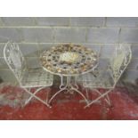 A weathered cream painted three piece iron work terrace set with decorative pierced scrolling