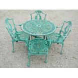 A weathered green painted cast aluminium garden terrace table of circular form with decorative