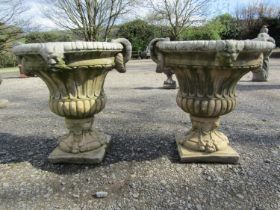 A pair of large weathered cast composition stone garden urns with lobed bodies, fixed ring