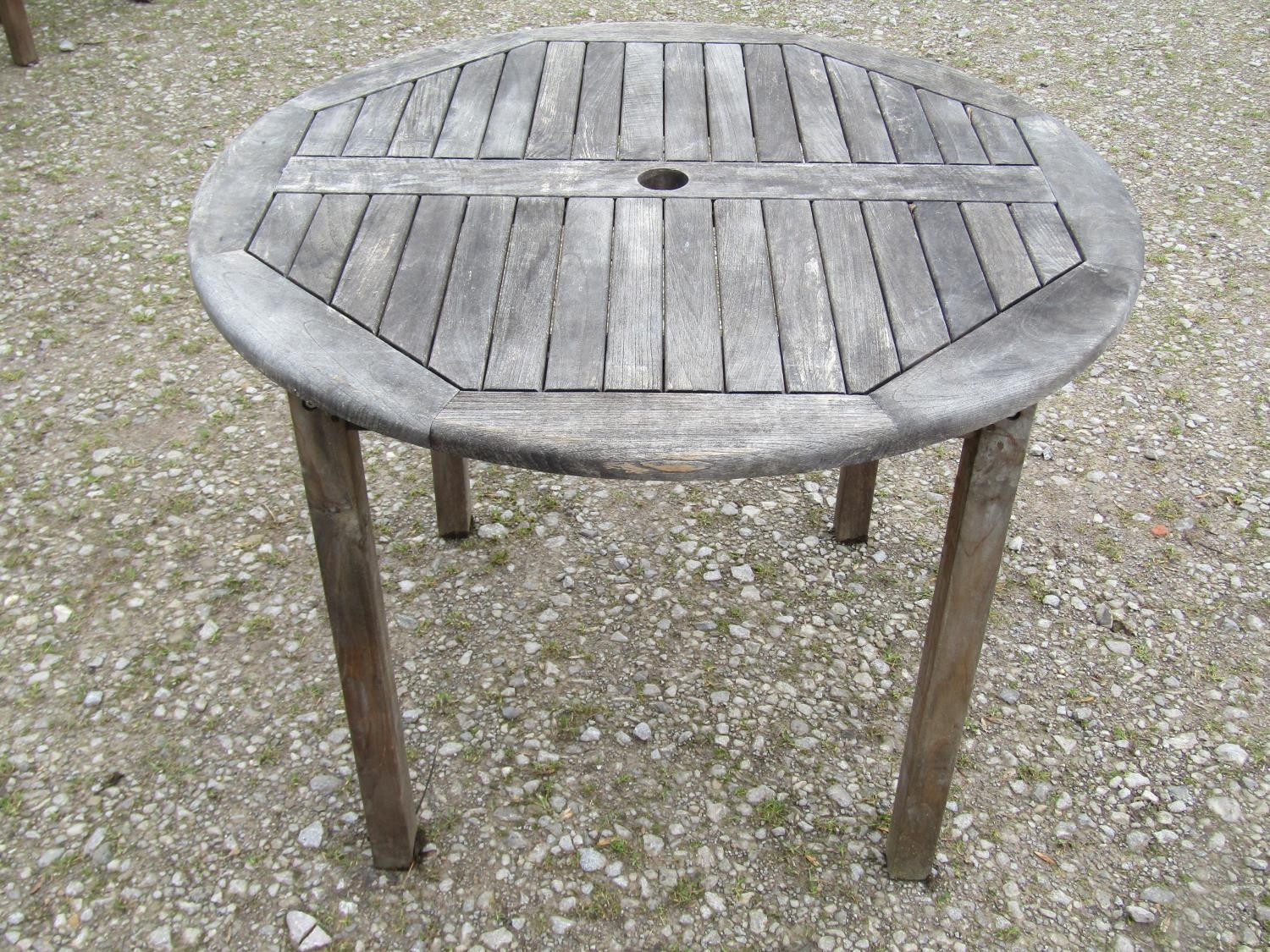 A weathered circular teak table and four associated armchairs (5) - Image 6 of 8