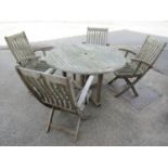 A Canterbury Collection weathered teak circular folding gateleg garden table and four matching