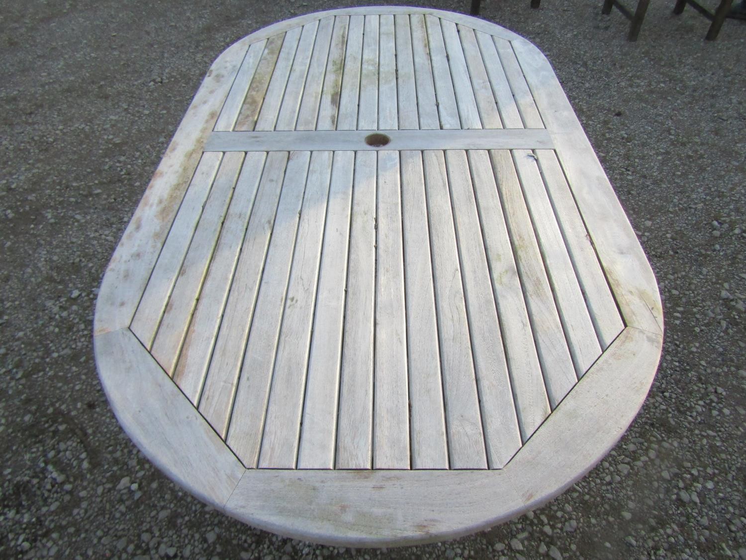 A contemporary Cotswold Collection weathered teak garden table with oval slatted top raised on - Image 4 of 6