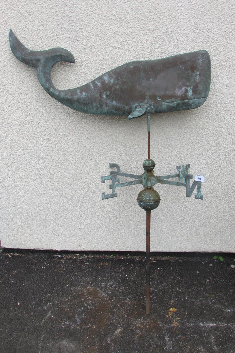 An unusual decorative weathervane in the form of a stylised blue wale, above spinning directional