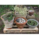 Three weathered cast composition stone square cut garden planters of varying size and design with