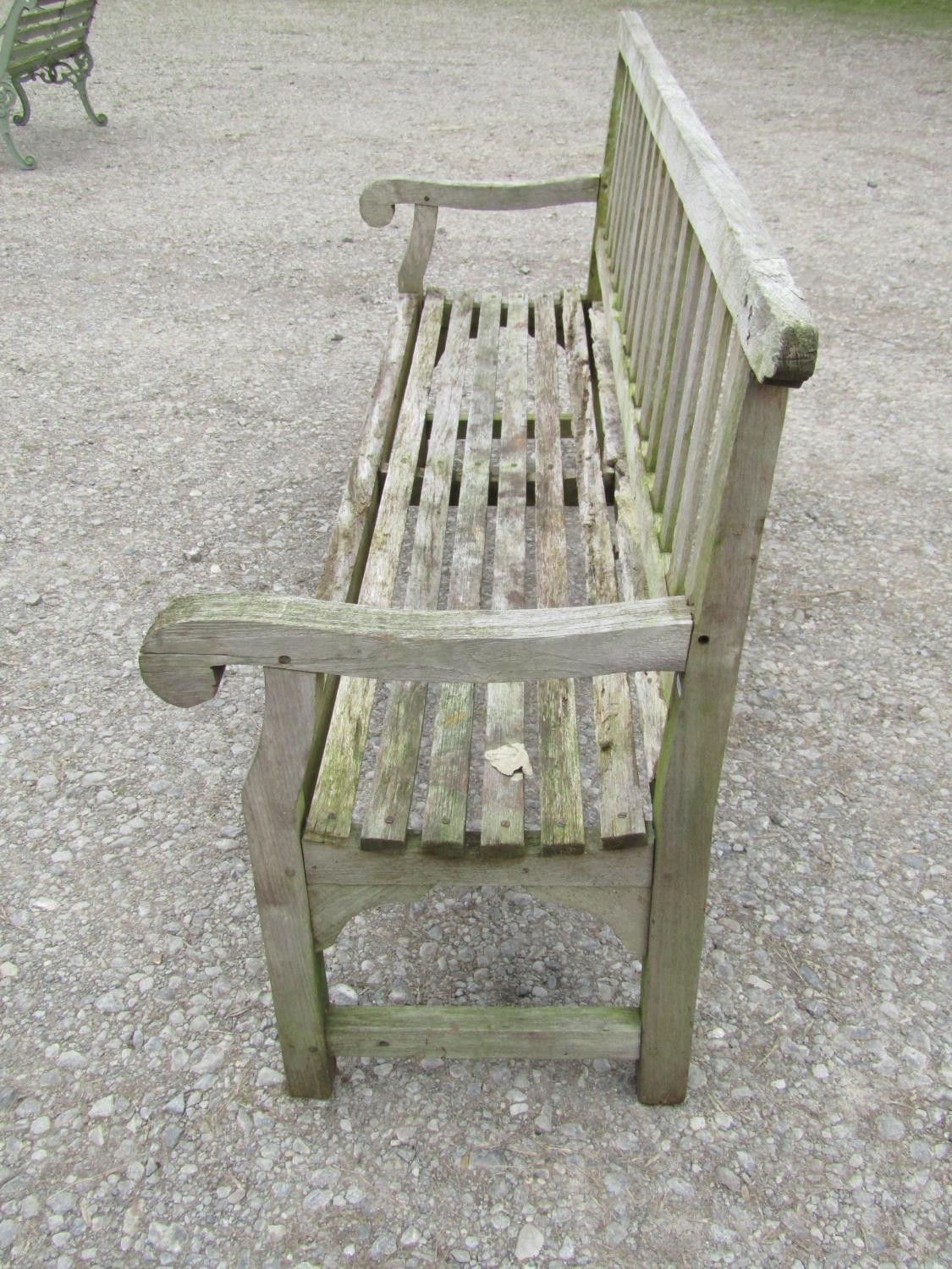A well weathered teak garden bench with slatted seat and back and open scrolled arms, 198 cm long ( - Image 2 of 7