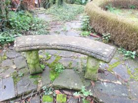 A weathered three-sectional cast composition stone garden bench, the curved slab seat with tongue