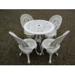 A small cream painted cast alloy garden terrace table with decorative pierced repeating scrolling