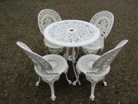 A small cream painted cast alloy garden terrace table with decorative pierced repeating scrolling