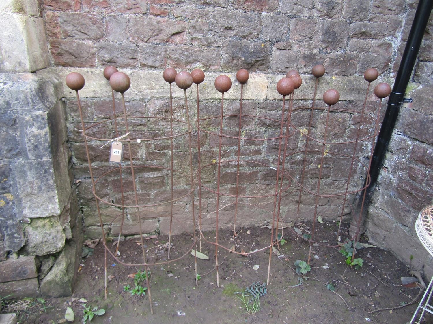 Three weathered light steel garden obelisks of cylindrical open ring form with ball finials, 120