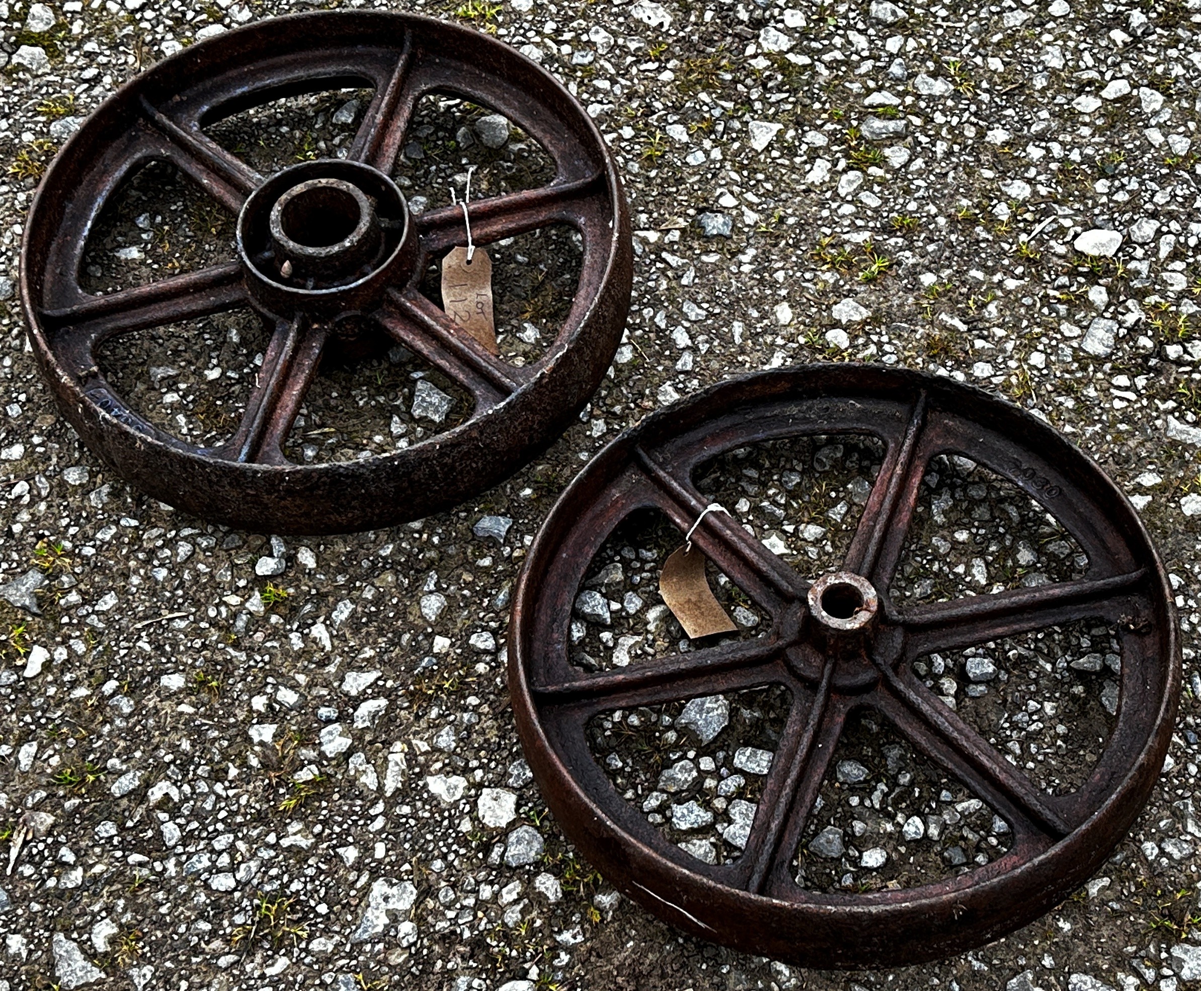 A pair of vintage cast iron implement wheels stamped with numbers 9340, 44 cm diameter