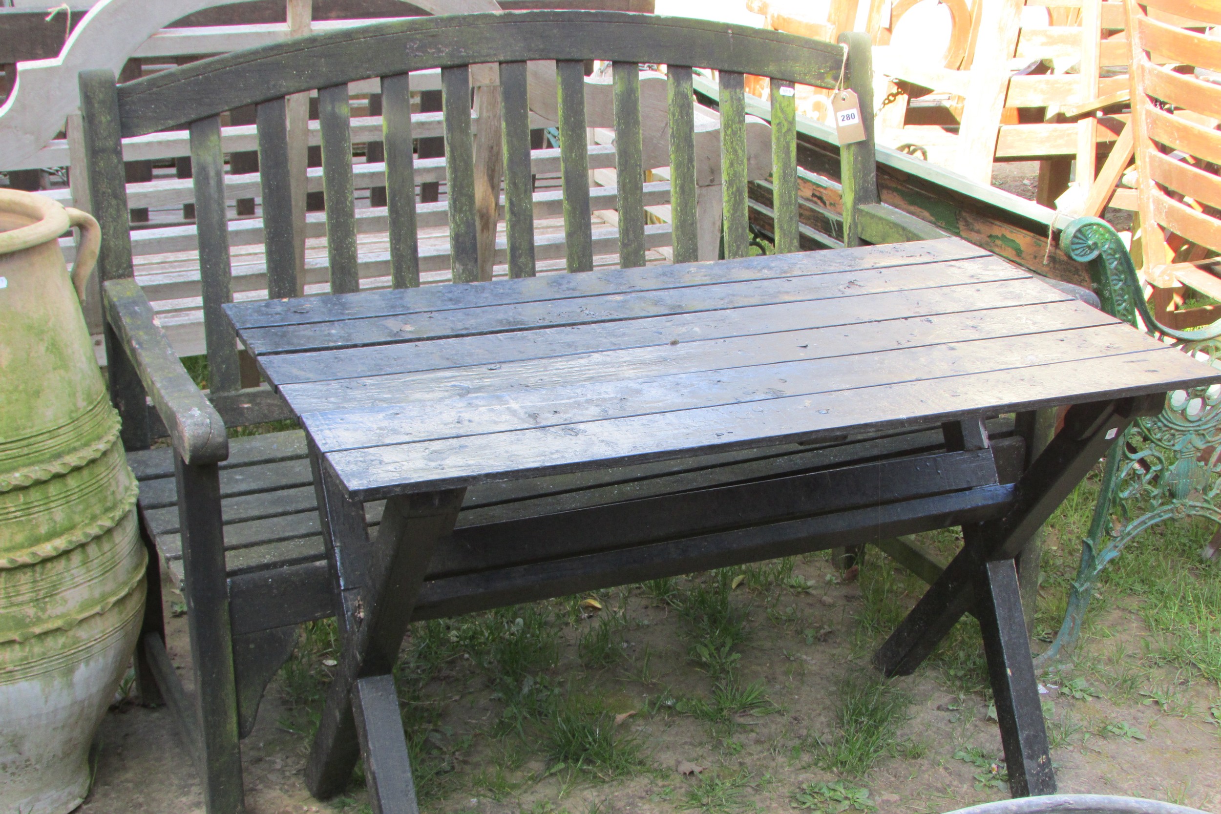 A weathered teak two seat garden bench with slatted seat and back beneath an arched rail 122 cm wide - Image 2 of 8