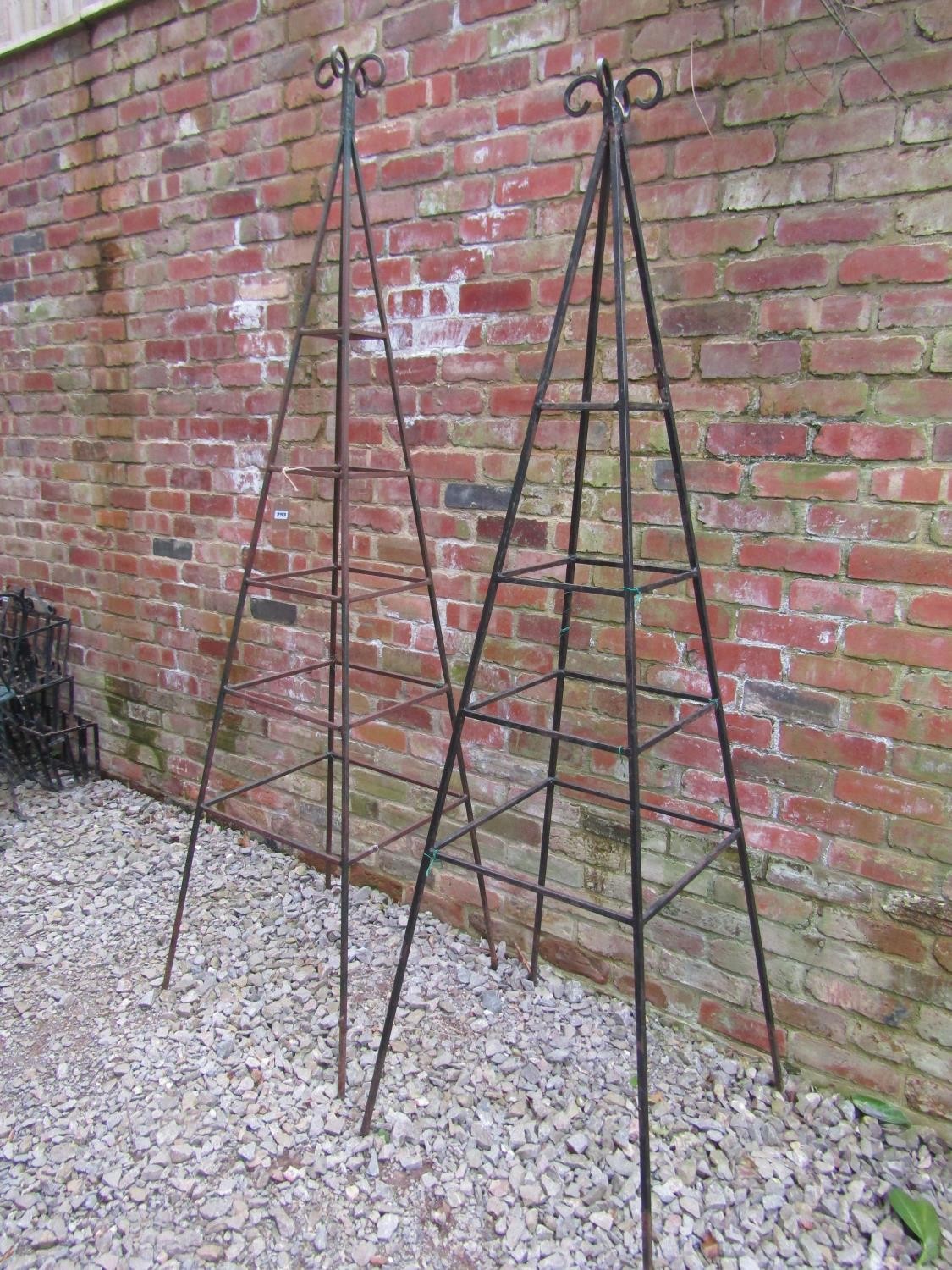 A weathered tall pyramid shaped steel garden obelisk with open scroll finial approx 240 cm high