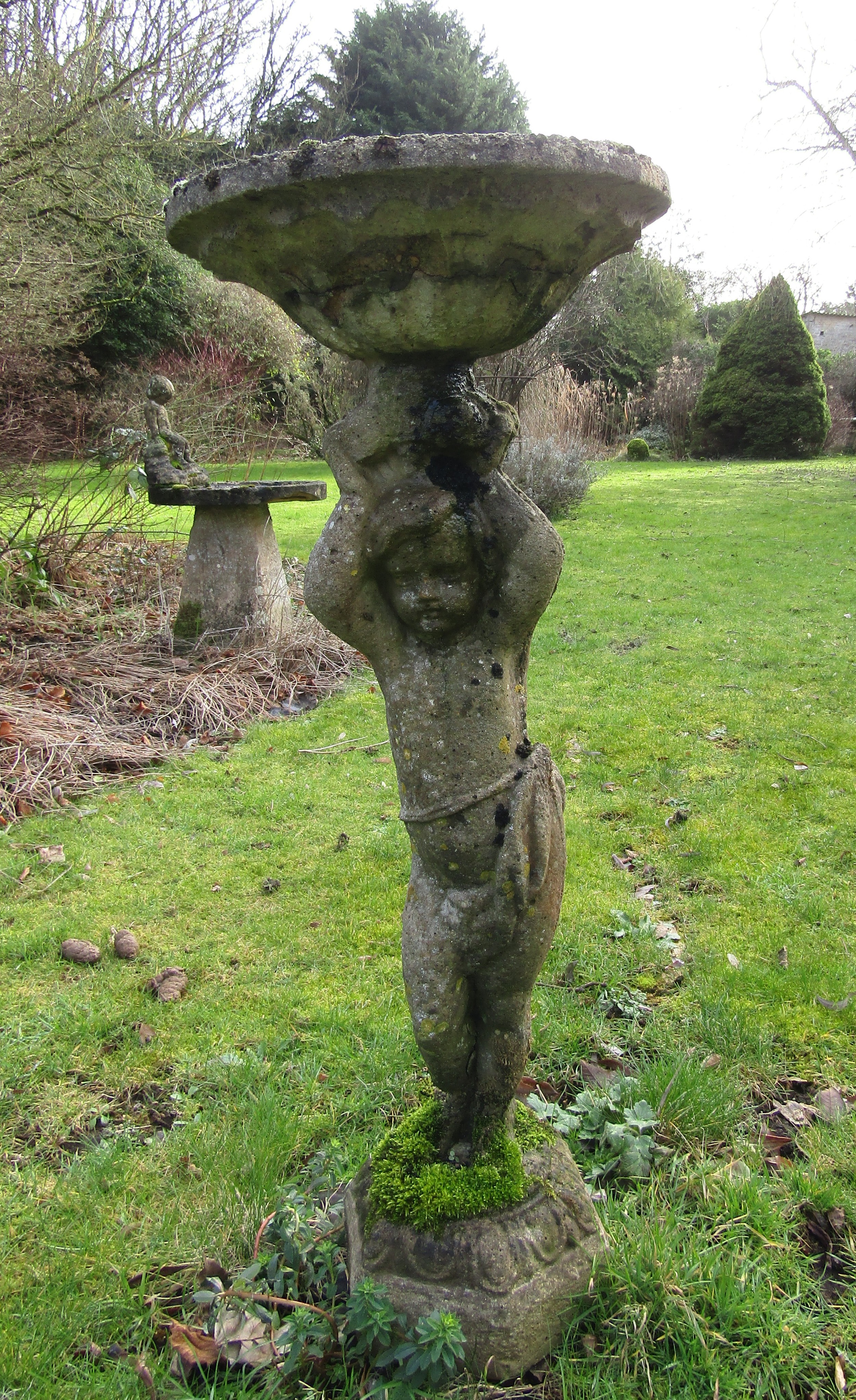 A weathered reconstituted bird bath, the column in the form of a boy, arms aloft, old repairs, 95 cm - Image 2 of 3