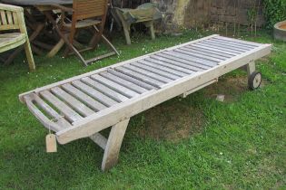 A Lindsey good quality weathered (silvered teak) two wheel garden sun lounger with adjustable