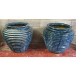 A pair of large blue glazed oviform planters with ribbed detail, 70 cm high x 76 cm diameter (at
