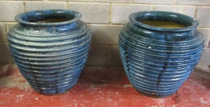 A pair of large blue glazed oviform planters with ribbed detail, 70 cm high x 76 cm diameter (at