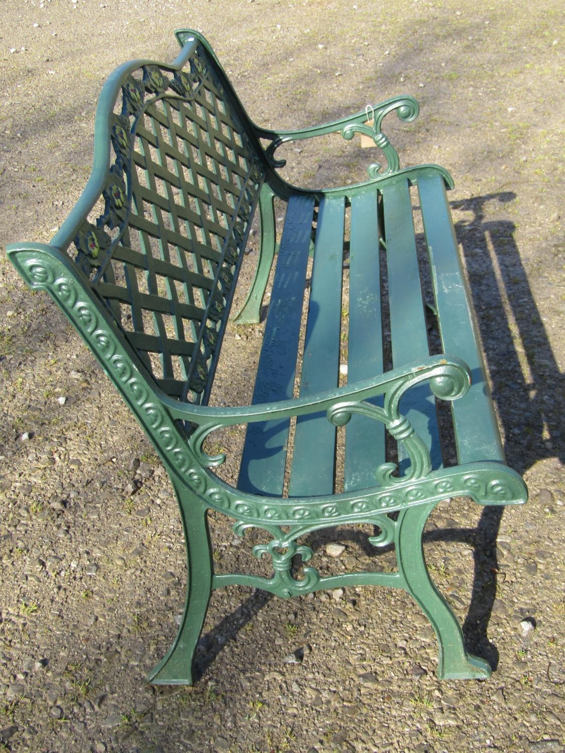 A green painted garden bench with wooden slatted seat beneath a cast iron pierced lattice panelled - Image 2 of 6