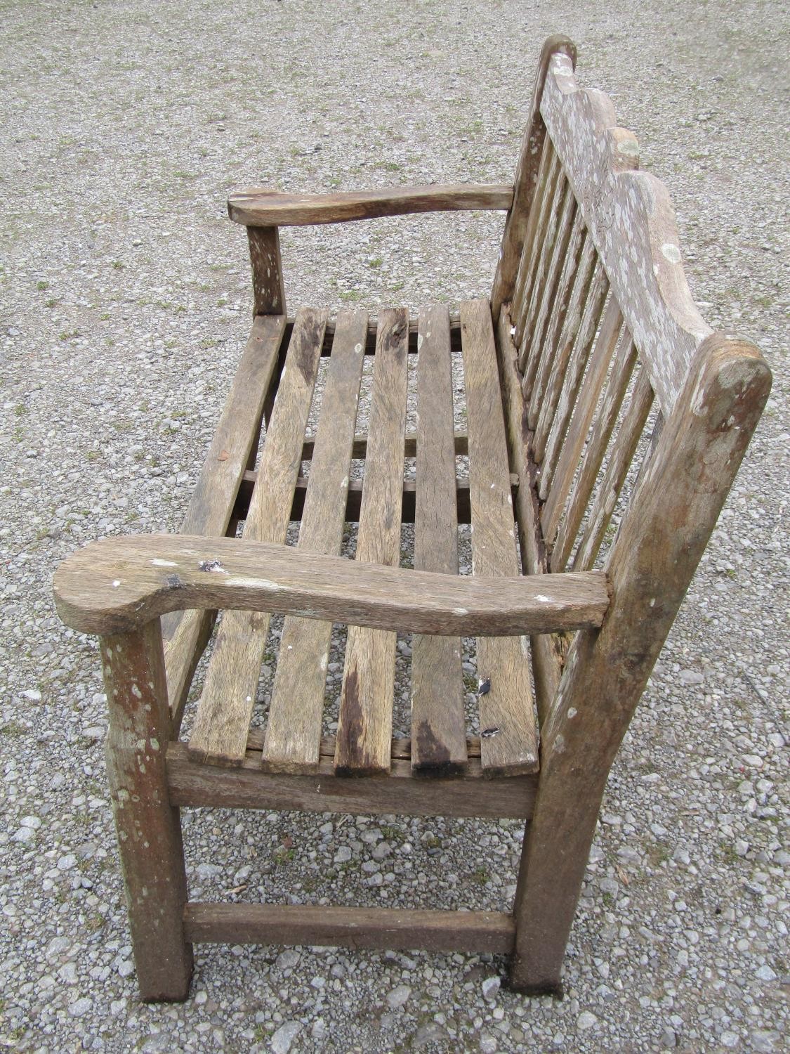 A Bridgman two seat weathered teak garden bench with slatted seat and back beneath a shaped rail - Image 2 of 3