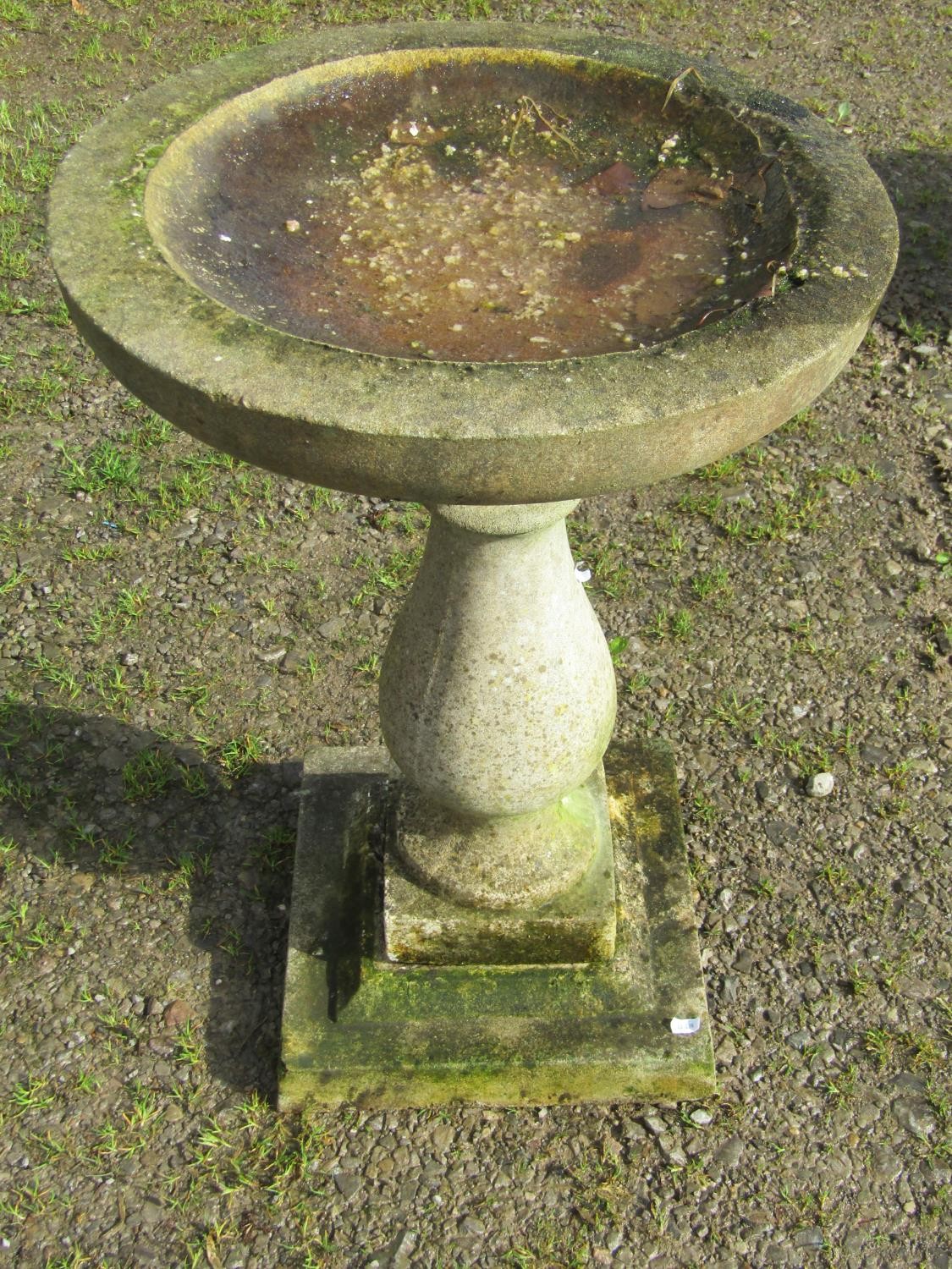 A weathered cast composition stone bird bath, raised on a baluster pedestal and square stepped base, - Image 2 of 2