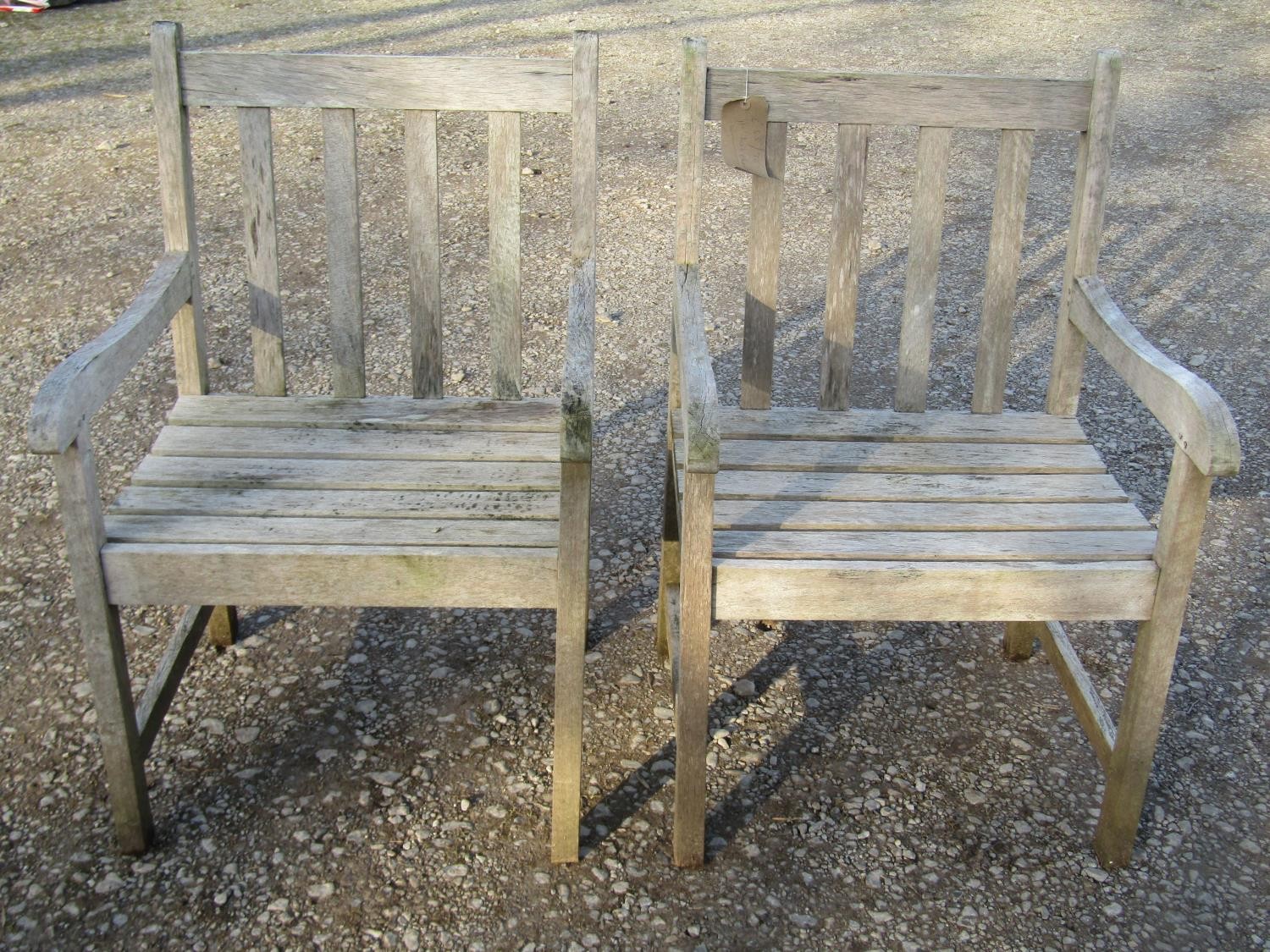 A pair of Firman weathered (silvered) teak garden open armchairs with slatted seats and backs (