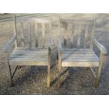 A pair of Firman weathered (silvered) teak garden open armchairs with slatted seats and backs (
