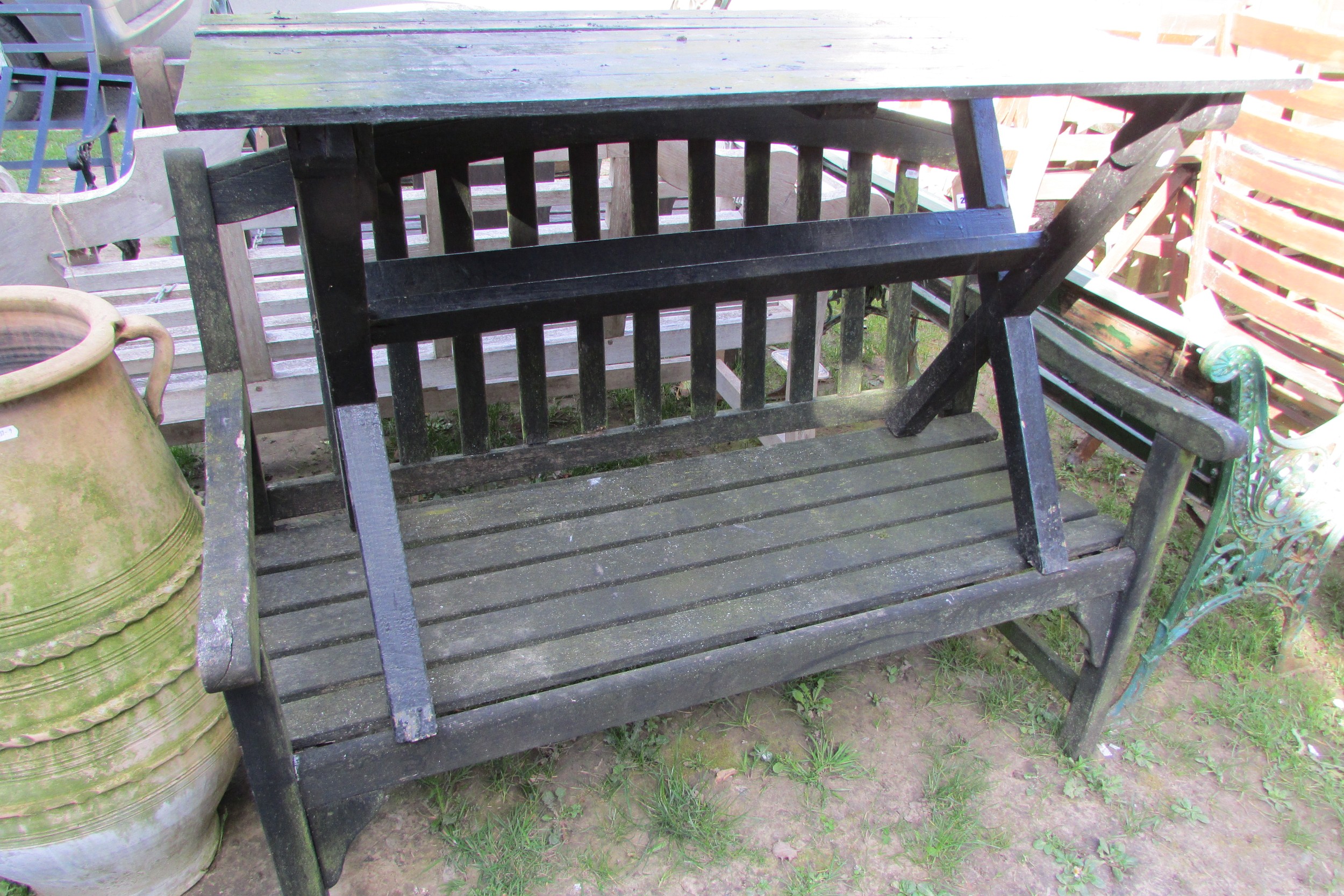 A weathered teak two seat garden bench with slatted seat and back beneath an arched rail 122 cm wide - Image 7 of 8