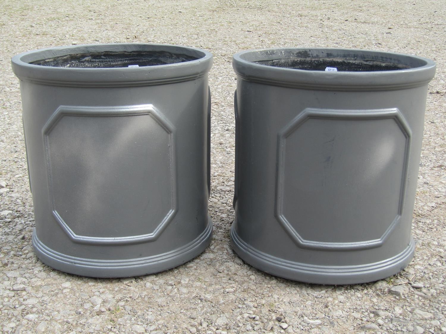 A pair of cylindrical fibre glass simulated lead planters with repeating panels, 38 cm high x 38