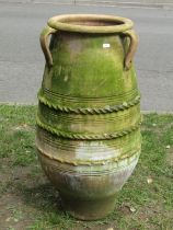 A weathered terracotta olive jar of oviform with three moulded loop handles incised and moulded