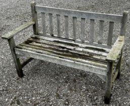 A weathered two seat garden bench with slatted seat and back (unmarked) but possibly a Lister