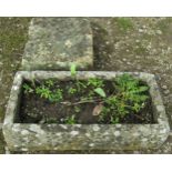 A weathered rectangular natural stone trough, 17cm high, 73cm x 39cm together with an associated