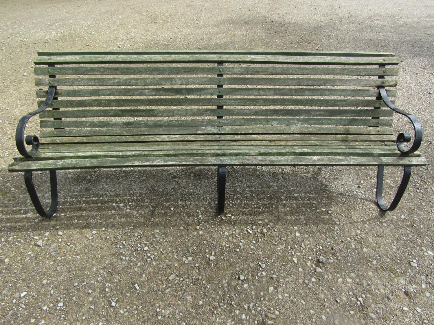 A vintage heavy gauge park/estate garden bench with weathered green painted teak slatted seat raised