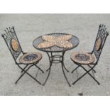 A heavy gauge three piece iron work Bistro table and two chairs with mosaic panels, lattice and