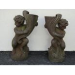A matched Victorian symmetrical pair of figural weathered cast iron planters, each in the form of