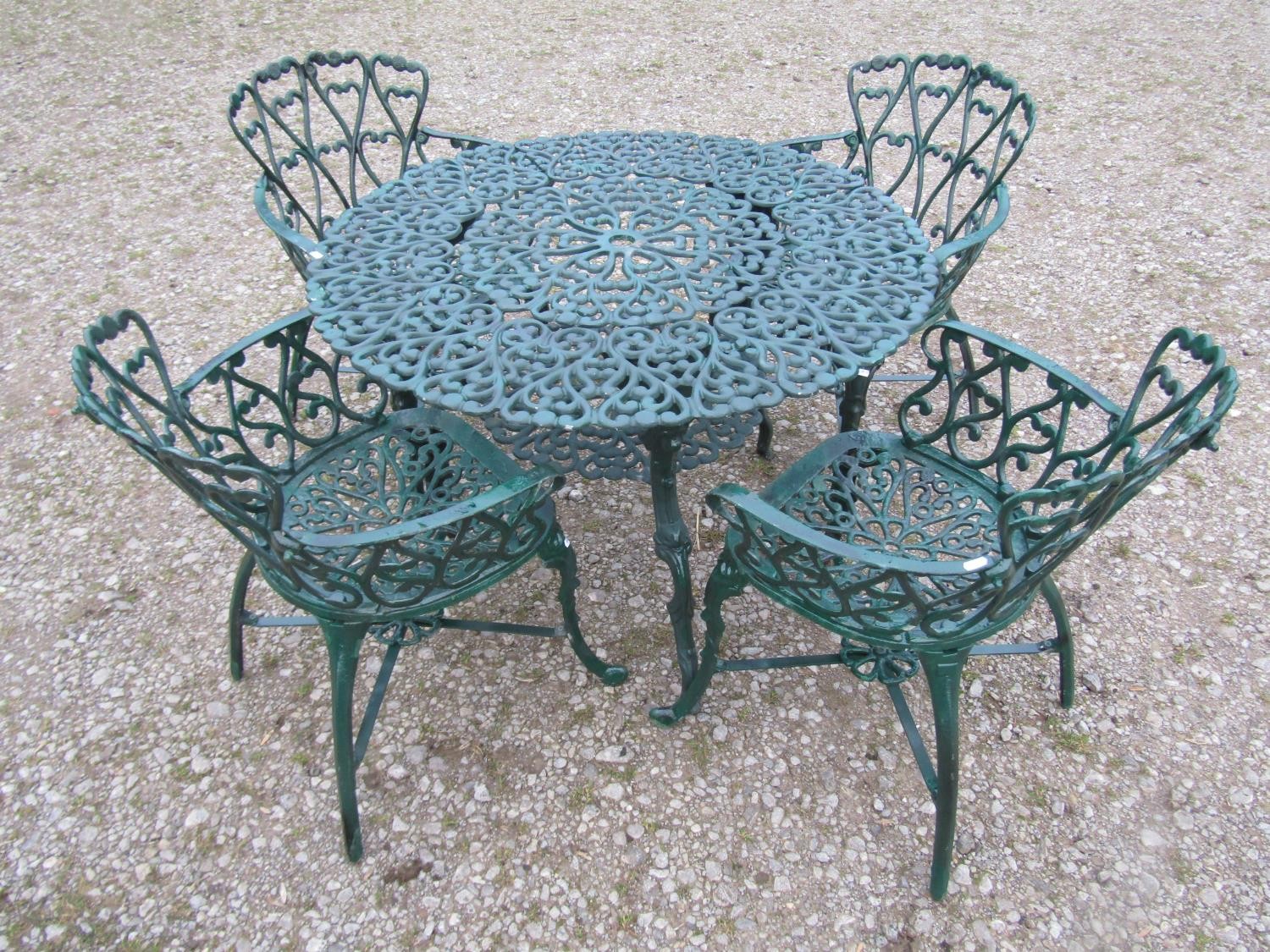 A green painted cast alloy circular two tier garden terrace table, with decorative repeating 'c'