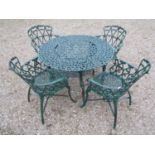 A green painted cast alloy circular two tier garden terrace table, with decorative repeating 'c'