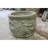 A small weathered squat cylindrical planter with winged cherub relief detail 20cm high x 30cm