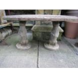 A novelty weathered three sectional composition stone garden table with oval top on standing otter