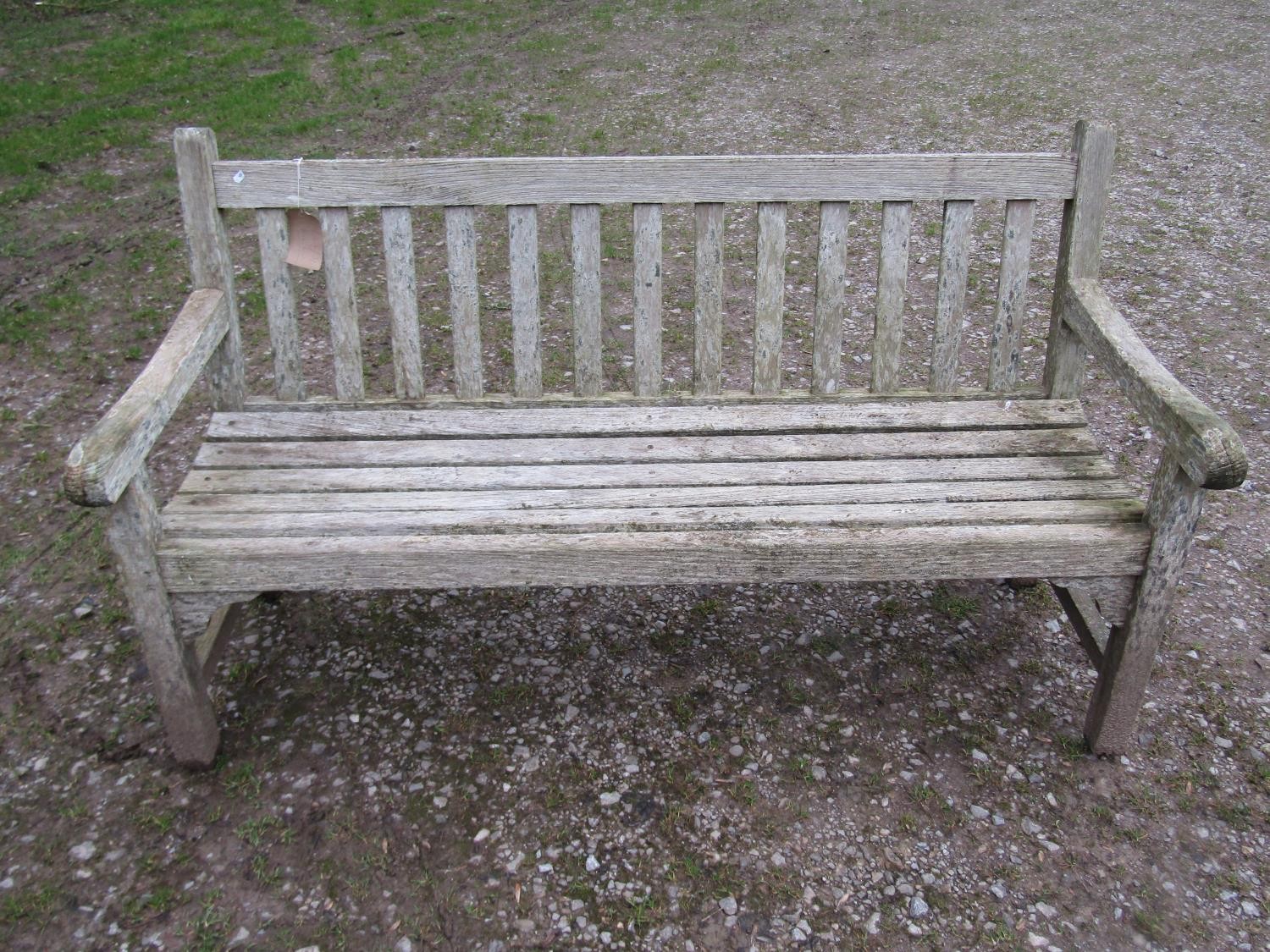 A weathered teak Tiger Trading three seat traditional garden bench with slatted seat and back, 153cm