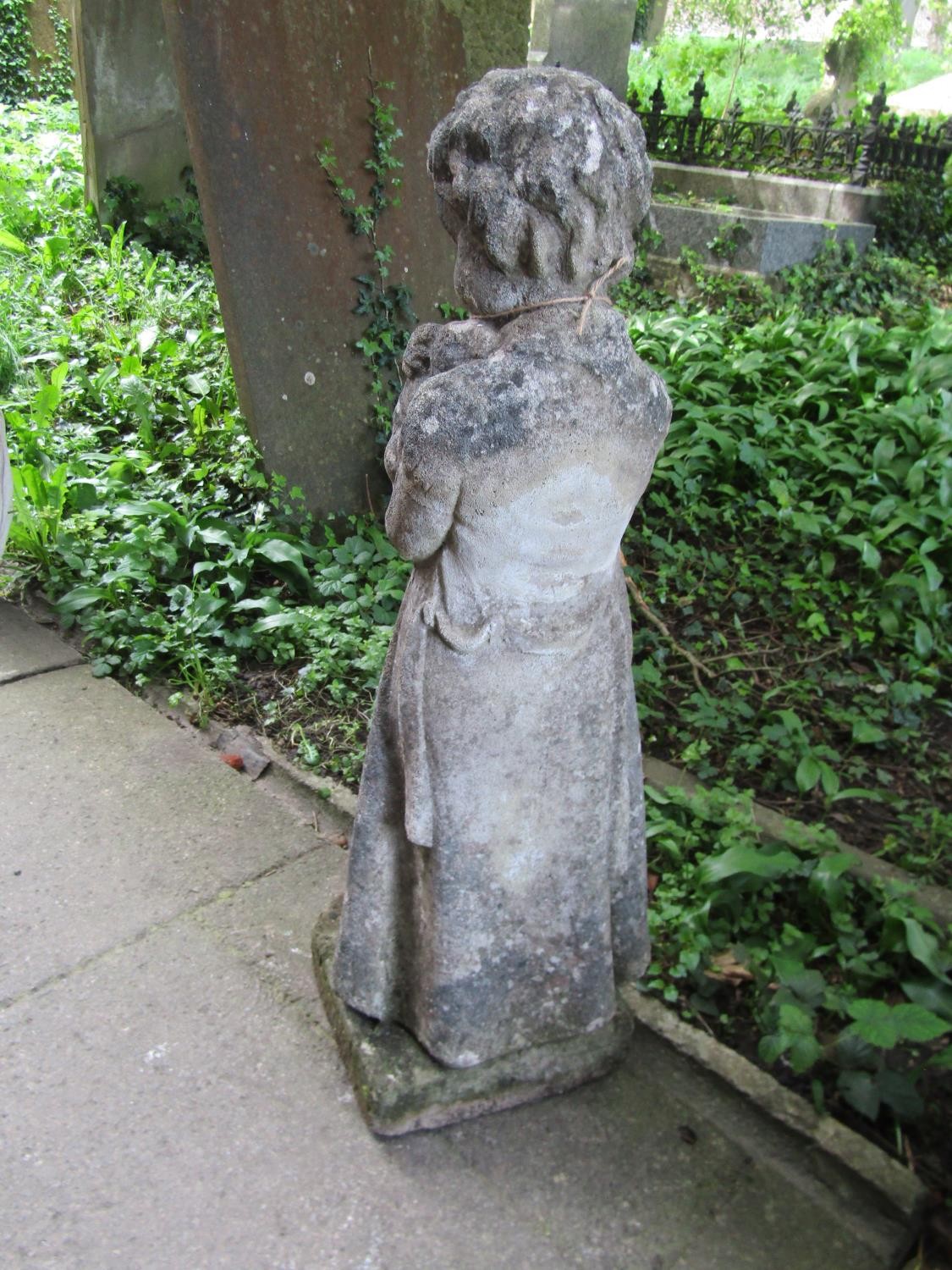 A weathered cast composition stone garden ornament in the form of a boy wearing a long trench coat - Image 3 of 4