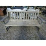 A weathered teak garden bench with slatted seat and back, with traces of painted finish, 162cm